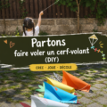 Un enfant souriant tenant un cerf-volant coloré dans un parc, prêt à le faire voler.