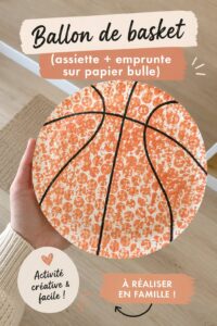 Un ballon de basket unique créé à partir d'une assiette et d'une empreinte sur papier bulle, idéal pour une activité manuelle en famille.